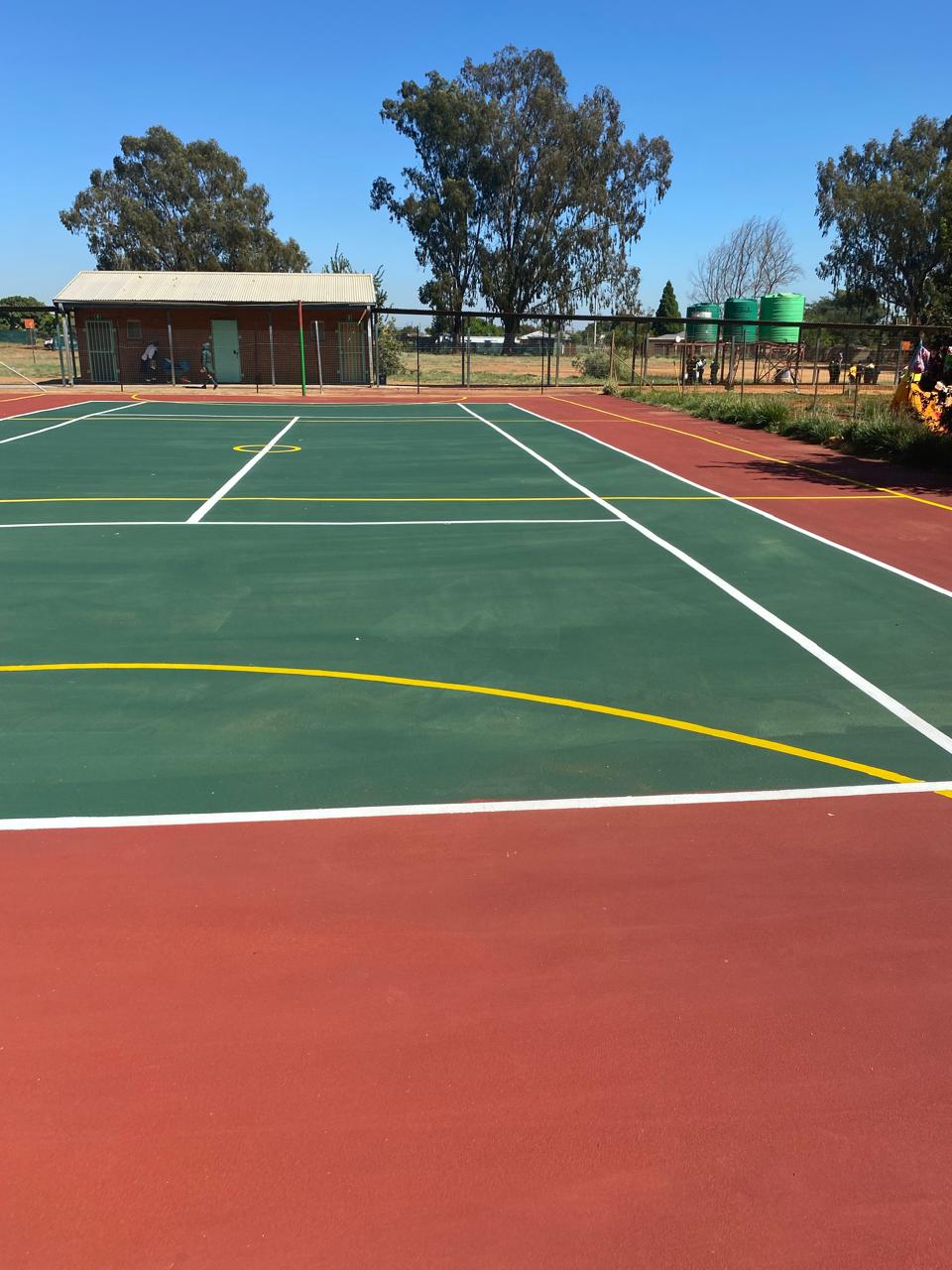 Multi-purpose sports court with red surround and green play area