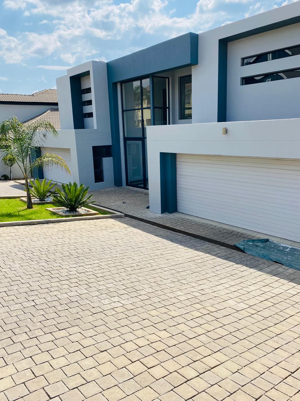 White and grey modern home with paver driveway