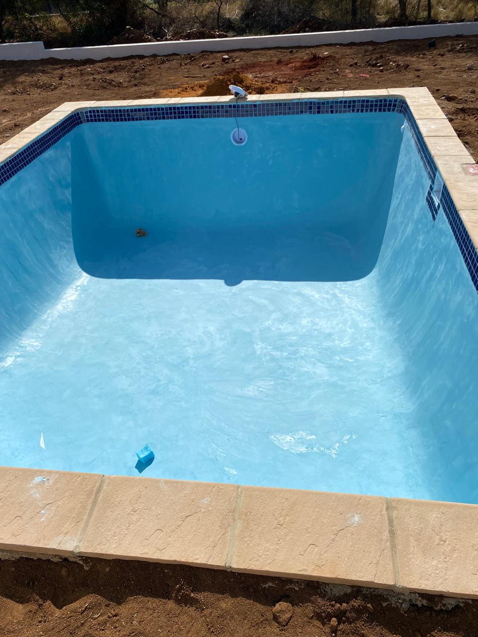 Newly plastered swimming pool with mosaic edge tiling